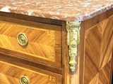a wooden chest of drawers with a marble top