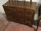 a wooden dresser with many drawers and a mirror on it