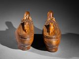 two wooden vases with figures on them sitting on a table