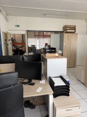 un bureau avec un écran d'ordinateur et une chaise dans une pièce