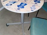a small table with chairs and a vase of flowers on it