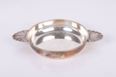 un plat en argent orné d'un motif de feuilles sur le bord
