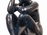 statue of a man sitting on a pedestal with his hand on his head