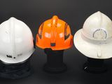 three hard hats sitting on top of each other on a black surface