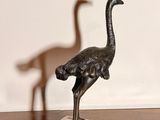 a statue of an ostrich and a bird on a table
