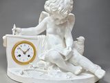 une statue blanche représentant un garçon assis sur une horloge