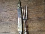 two forks and a knife on a wooden table