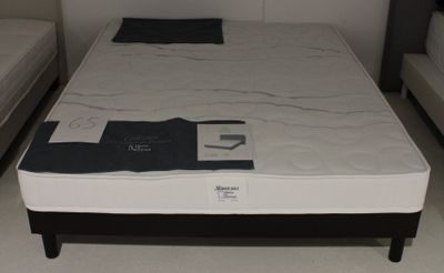 un lit sur lequel est posé un matelas dans une pièce
