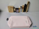 un sac rose posé sur une table à côté de quelques livres