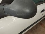 a side view mirror of a white car with black trims
