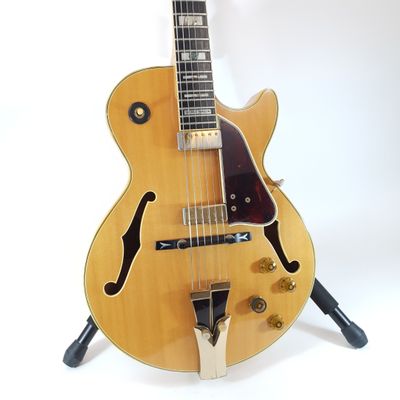 an electric guitar sitting on top of a stand on a white surface