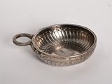 an antique silver plate with a handle on a white surface