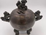an antique bronze incense box with three monkeys on it