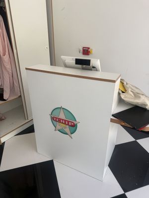 une boîte blanche ornée d'un logo, posée sur un sol à damier noir et blanc