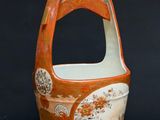 a small vase with a handle on a wooden table