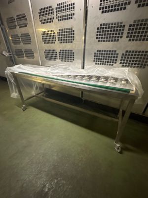 un banc en métal avec un plateau en verre, placé au milieu d'une pièce