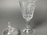 two glass goblets sitting on top of a table next to each other