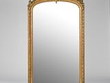 un grand miroir à cadre doré orné d'un motif décoratif
