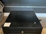 a black metal box sitting on the floor next to a pile of luggage