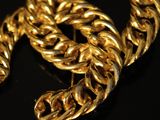 a close up of a gold chain bracelet on a black surface