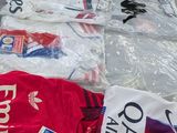 many shirts that are on a table in a room