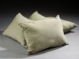 three pillows on a gray surface with a black background