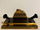 a gold plate with two black speakers on top of it