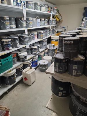 de nombreux pots de peinture sur les étagères du magasin