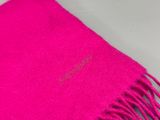 un gros plan sur une écharpe rose vif posée sur une table