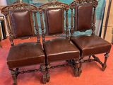 three brown leather chairs sitting next to each other on a red carpet