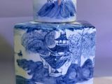 a blue and white jar with a painting on it