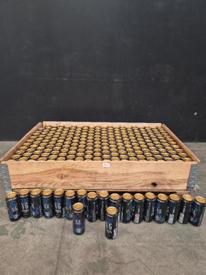 une caisse en bois contenant des canettes de bière, posée par terre