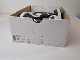 a box with a pair of black and white shoes in it