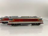 a red and silver train on a white surface