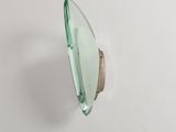 a close up of a green glass object on a white surface