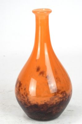 an orange vase sitting on a table with a white background