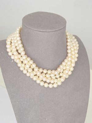 a white pearl necklace on a mannequin with a gold clasp