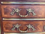 a wooden chest of drawers with brass handles on it