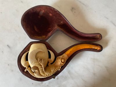 une pipe en bois et une cuillère en bois posées sur une table