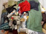 a pile of clothes and other items on a bed