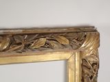 a mirror with a gold frame on a white wall
