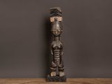 une statue en bois représentant un homme debout sur une table en bois