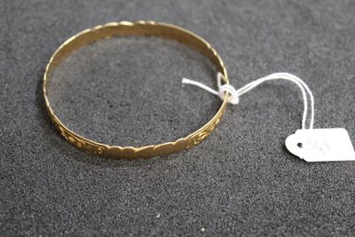 a close up of a gold bracelet with a tag on it