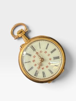 une vieille montre de poche en or avec des chiffres romains et des chiffres romains sur le cadran