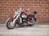 a red motorcycle that is parked in front of a brick wall
