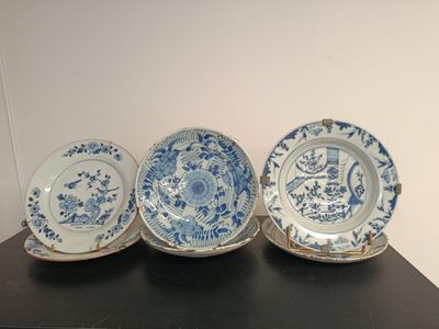 three blue and white china plates on a black table