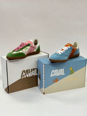 two pairs of shoes are sitting on top of a cardboard box