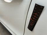 a measuring stick on the door of a white car