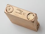 a gold lighter that is sitting on a white surface