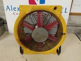 an old fan sitting on top of a table in front of a sign